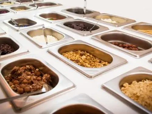 mesa com diversos complementos para açaí e cupuaçu